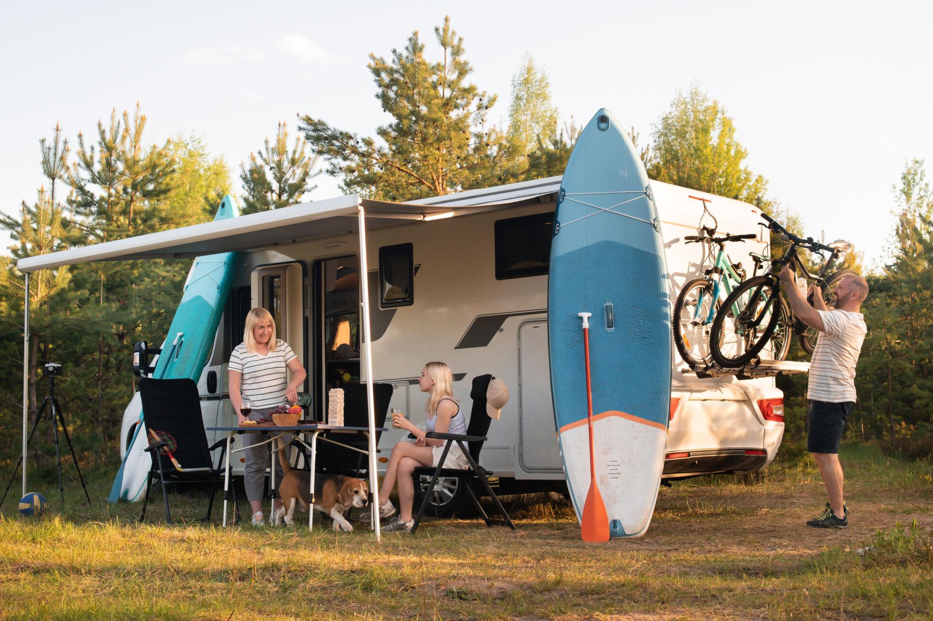 A family sets up camp outside of their RV.